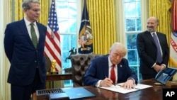 Президент Дональд Трамп підписує розпорядження про створення фонду у присутності міністра фінансів Скотта Бессента (ліворуч) і кандидата на посаду міністра торгівлі Говарда Латника в Овальному кабінеті Білого дому, понеділок, 3 лютого 2025 року, Вашингтон. AP Photo/Evan Vucci