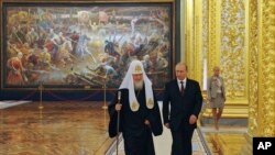 Російська православна церква є партнером Путіна, вона ідеологічно забезпечує імперські зазіхання, вважають аналітики. Архівне фото: Президент Росії Володимир Путін і патріарх РПЦ Кирил на прийомі в Кремлі в Москві, Росія, 4 листопада 2014 року. (Sputnik/AP)