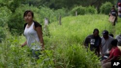 Guatemalan migrant Gladys Chinoy, 14, waits for a train June 20, 2014 in a remote area outside Reforma de Pineda, Chiapas state, Mexico. Chinoy memorized her mother's phone numbers in New York and joined a group of women and children traveling with a smuggler paid to take migrants to the U.S. (AP Photo/Rebecca Blackwell)