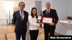 北京人权律师余文生的妻子许艳在领奖后与德法两国大使合影。(推特截图)