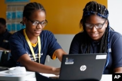 Jahiem Johnson, 13, left, helps classmate Kamya Saunders, 13, as they work on an English passage during class at the Washington Leadership Academy in Washington, Aug. 23, 2017. The school utilizes "personalized learning."
