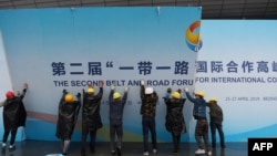 在第二届一带一路国际合作高峰论坛闭幕后，中国工人拆掉宣传板。（2019年4月27日）