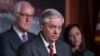 Sen. Lindsey Graham, R-S.C., flanked by Sen. John Cornyn, R-Texas, left, and Sen. Katie Britt, R-Ala., speaks to reporters as they criticize President Joe Biden's policies on the US-Mexico border, at the Capitol in Washington, Thursday, Dec. 7, 2023.
