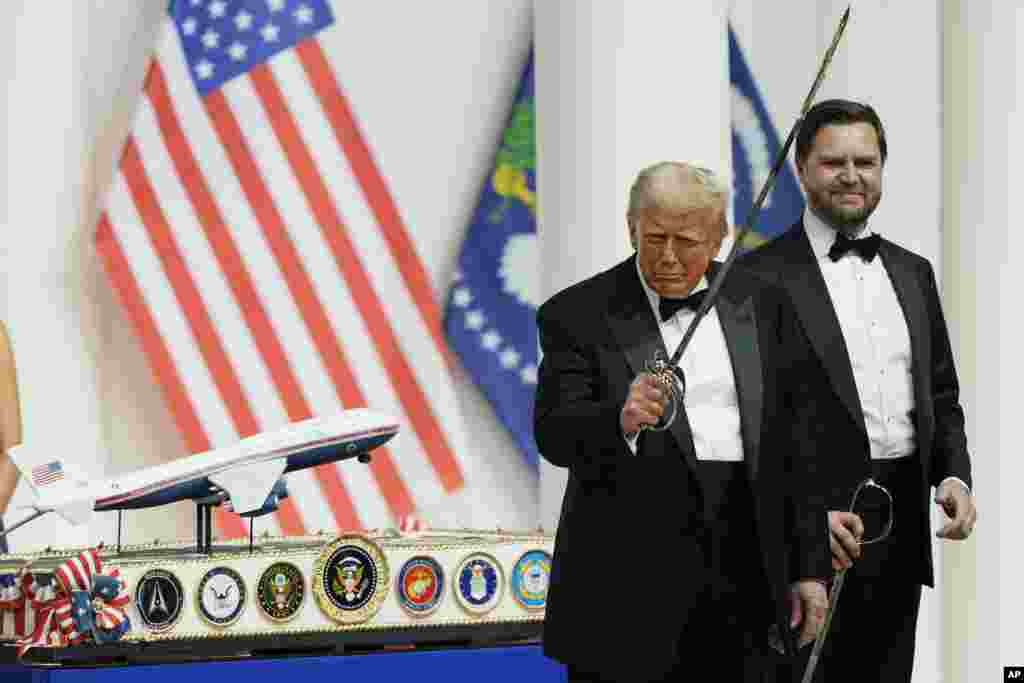 Президент Дональд Трамп держит саблю после разрезания ею торта с миниатюрой президентского самолета Air Force One на балу главнокомандующего. За спиной Трампа стоил вице-президент Вэнс.