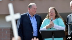 Rowan County Clerk Kim Davis, with Republican presidential candidate Mike Huckabee, left, at her side, speaks after being released from the Carter County Detention Center in Grayson, Kentucky, Sept. 8, 2015. (AP Photo/Timothy D. Easley)