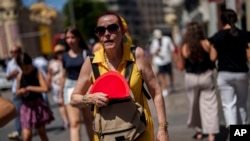 FILE - A woman fans herself in Madrid, Spain, July 10, 2023. Earth last year shattered global annual heat records, the European climate agency said Tuesday, Jan. 9, 2024. (AP Photo/Manu Fernandez, File)