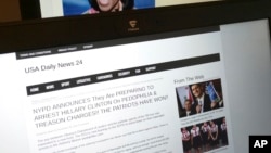 This photograph taken in Paris Friday Dec. 2, 2016 shows stories from USA Daily News 24, a fake news site registered in Veles, Macedonia.