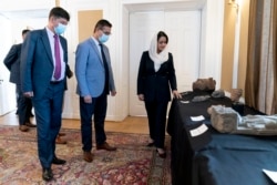 Afghan Ambassador to the U.S. Roya Rahmani, right, accompanied by embassy staff, speaks as she gives the Associated Press a tour at the Afghanistan Embassy in Washington, Wednesday, April 21, 2021