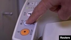 A person presses a button on the control panel of a Japanese toilet, in Tokyo, Japan September 22, 2019. (REUTERS/Lucien Libert)