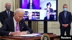 U.S. President Joe Biden signs an executive order as part of his administration's plans to fight the coronavirus disease (COVID-19) pandemic during a COVID-19 response event as Dr. Anthony Fauci and COVID-19 czar Jeff Zients listen at the White House January 21, 2021. REUTERS