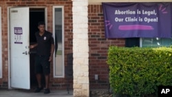 A security guard opens the door to the Whole Women's Health Clinic in Fort Worth, Texas, Wednesday, Sept. 1, 2021. The U.S. Supreme Court refused to block a Texas law that activists say effectively bans abortions in the nation’s second-largest state. (AP Photo/LM Otero)