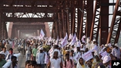 Des pèlerins hindous marchent avec des drapeaux sur un pont bondé après une bousculade à la périphérie de Varanasi, Inde, 15 octobre 2016. 