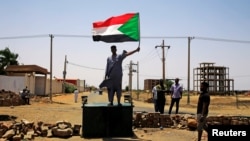 Un manifestant soudanais porte un drapeau national, exigeant que le Conseil militaire de transition transfère le pouvoir aux civils, à Khartoum (Soudan), le 5 juin 2019.