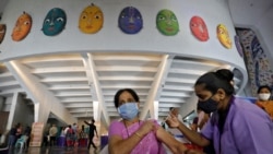A woman receives a dose of COVISHIELD, a coronavirus disease (COVID-19) vaccine manufactured by Serum Institute of India, at an auditorium, which has been converted into a temporary vaccination centre, in Ahmedabad, India, March 26, 2021. REUTERS/Amit Dav