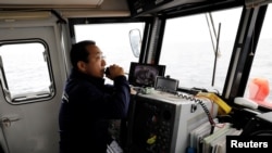 Whale-watching boat captain Masato Hasegawa speaks with other boats in order to look for whales in the sea near Rausu, Hokkaido, Japan, July 1, 2019.(Reuters)