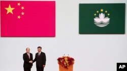 FILE - Macao Chief Executive Ho Iat Seng, left, poses with Chinese leader Xi Jinping for a photo after taking his oath at the inauguration ceremony in Macao, Friday, Dec. 20, 2019 to mark the 20th anniversary of the former Portuguese colony's handover to Chinese rule. 