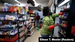 Wendy Weaver place des produits sur les étagères du magasin dont elle est propriétaire avec son mari à Evanston, Illinois, États-Unis, le 17 mars 2021.