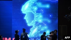 2024年9月10日在首尔举行的军事领域负责任人工智能（REAIM）峰会闭幕式前，参与者在电子图像前聊天。