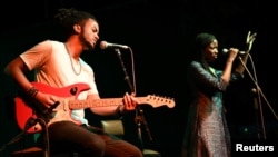 Guitarist Brahim Wone and singer Awa Ly perform on stage at the Saint Louis Jazz Festival in Saint Louis, Senegal, June 18, 2021. (REUTERS/Cooper Inveen)