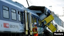 Des secouristes en train de rechercher des survivants après la collision entre deux trains près de Granges-pres-Marnand, Suisse, le 29 juillet 2013. 