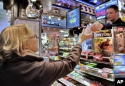 FILE - Age Diedrick, 68, purchases her lottery ticket in New York for a chance at the historic Mega Millions jackpot that reached more than $600 million on Friday, March 30, 2012. (AP Photo/Bebeto Matthews)