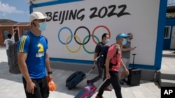 到河北省张家口崇礼的游客走过北京2022冬季奥运会的广告牌。（2020年8月13日）