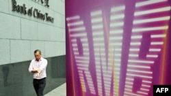 资料照 - 一位白领人士走过中国银行（香港）贴有“RMB" （人民币）字样的招贴画。照片摄于2011年9月5日。