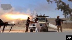 Des combattants islamistes de la Brigade Misarata tirent en direction de l'aéroport de Tripoli, Libye, pour en chasser une puissante milice rivale , le 26 juillet 2014. 