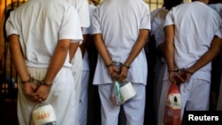 资料照片:2019年12月27日，萨尔瓦多查拉特南戈，MS-13团伙成员等待登上一辆从查拉特南哥监狱转移的公共汽车。 