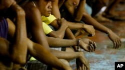 Rounded up residents, mostly males, wait to be transported to a police station in the continuing operation of President Rodrigo Duterte's so-called "War on Drugs" campaign, at the slum community of Tondo, in Manila, Philippines, Sept. 30, 2016.