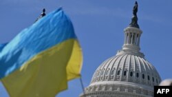 Фото для ілюстрації: активісти з прапором України під будівлею парламенту у США, квітень 2024 рік