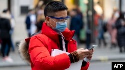 Un piéton porte un masque de protection sur Regent Street à Londres, le 25 janvier 2020.