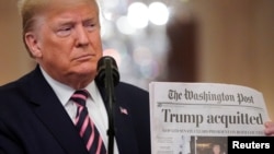 Le président américain Donald Trump tient le Washington Post qui titre en Une son acquittement au Sénat, à Washington, le 6 février 2020.