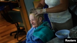 FILE - An Alzheimer's patient has her hair done inside the Alzheimer foundation in Mexico City April 19, 2012. Alzheimer’s slowly attacks areas of the brain needed for memory, reasoning, communication and basic, daily tasks. 