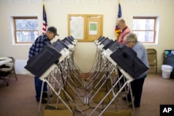 Voters cast their ballots in the primary election Tuesday, March 15, 2016, in Chesterville, Ohio. Voters in five states are making their choices in party primaries. (AP Photo/Matt Rourke)