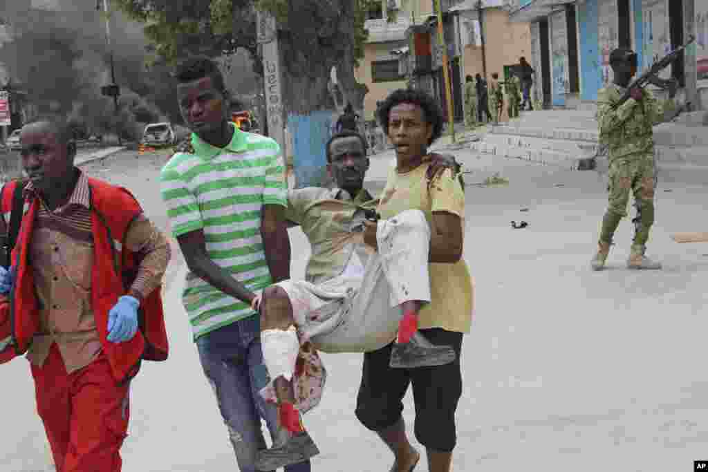 Deux civils somaliens emmènent un blessé de l&#39;attentat à Mogadiscio, en Somalie, le 30 juillet 2017.