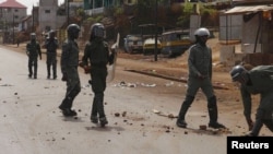Des policiers anti-émeutes patrouillent dans une rue de Conakry après une manifestation, le 7 mai 2015.