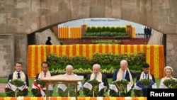 2023年9月10日出席新德里G20峰会的法国总统马克龙、印尼总统维多多、印度总理莫迪、巴西总统达席尔瓦马杜罗、美国总统拜登、 英国首相苏纳克、以及欧盟委员会主席冯德莱恩同其他G20集团国家领导人一起拜谒了拉吉夫·甘地的纪念馆。（Kenny Holston/Pool via REUTERS）