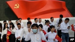 北京的中国共产党历史展览馆内一群年轻人准备在中共党旗下拍照。（2022年10月12日）