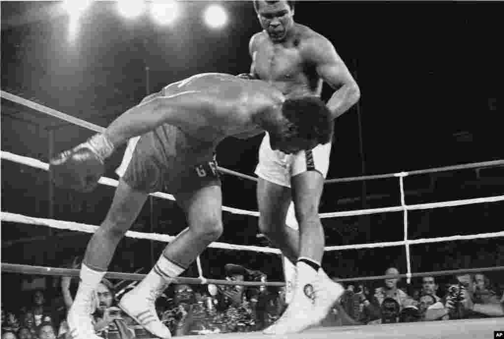 In this Oct. 30, 1974, file photo, challenger Muhammad Ali watches as defending world champion George Foreman goes down to the canvas in the eighth round of their WBA/WBC championship match in Kinshasa, Zaire.