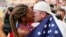 Tara Davis-Woodhall and husband Hunter Woodhall kiss after she won the silver medal for the U.S. in the women's long jump final at the World Athletics Championships in Hungary, Aug. 20, 2023. They have been called track and field's power couple. (AP Photo/Matthias Schrader, File)
