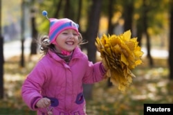 Kids all over the world like to play in the fallen leaves of autumn.