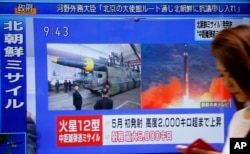 A woman walks past a TV screen broadcasting news of North Korea's missile launch, in Tokyo, Aug. 29, 2017. North Korea fired a ballistic missile from its capital Pyongyang that flew over Japan before plunging into the northern Pacific Ocean.
