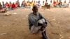 Un homme attend de recevoir une aide alimentaire à l'extérieur d'un camp de survivants déplacés du cyclone Idai à Dombe, au Mozambique, le 4 avril 2019.