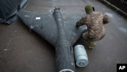 Украинский военнослужащий осматривает сбитый беспилотник с термобарическим зарядом, 14 ноября 2024 года.