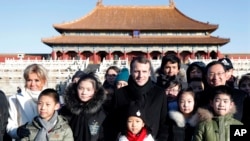 French President Emmanuel Macron, center, and his wife Brigitte Macron, left, pose for a photo with Chinese and French schoolchildren during a visit to the Forbidden City in Beijing Tuesday, Jan. 9, 2018. (Charles Platiau/Pool Photo via AP)