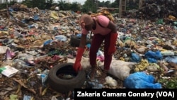 Aïcha Traoré, jeune créatrice, ramasse des pneus usés dans une décharge, à Conakry, Guinée, 13 septembre 2018. (VOA/ Zakaria Camara Conakry)