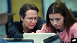 Jennifer Rocca, left, a teacher librarian at Brookfield, Conn., High School, works with Ariana Mamudi, 14, a freshman in her Digital Student class, Dec. 20, 2017.
