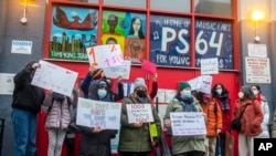 Teachers from the Earth School speak out on issues related to lack of coronavirus testing outside P.S. 64, Dec. 21, 2021, in New York. (AP Photo/Brittainy Newman, File)