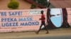 Un jeune garçon passe devant un mur avec des graffitis exhortant les gens à porter des masques à Harare, le 28 mai 2020.